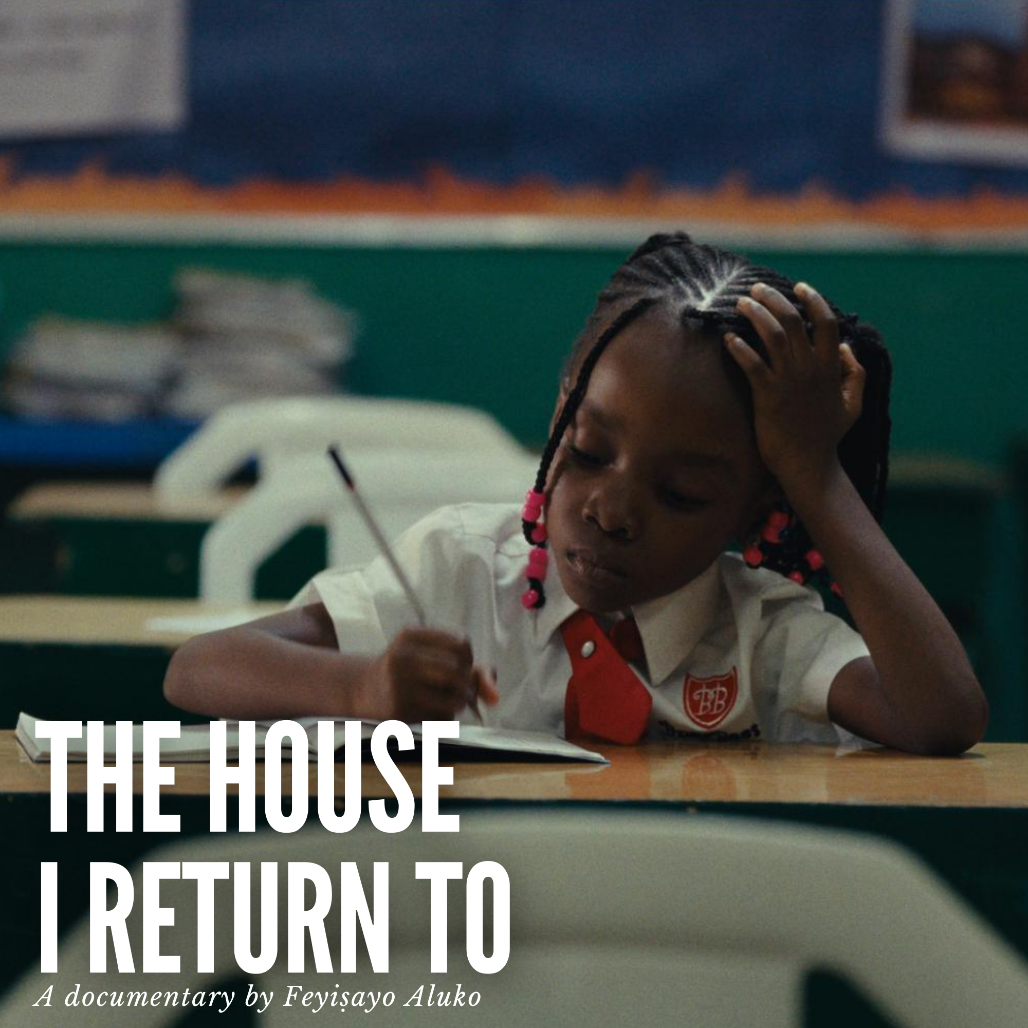 A little girl wearing a school uniform and writing at her desk.