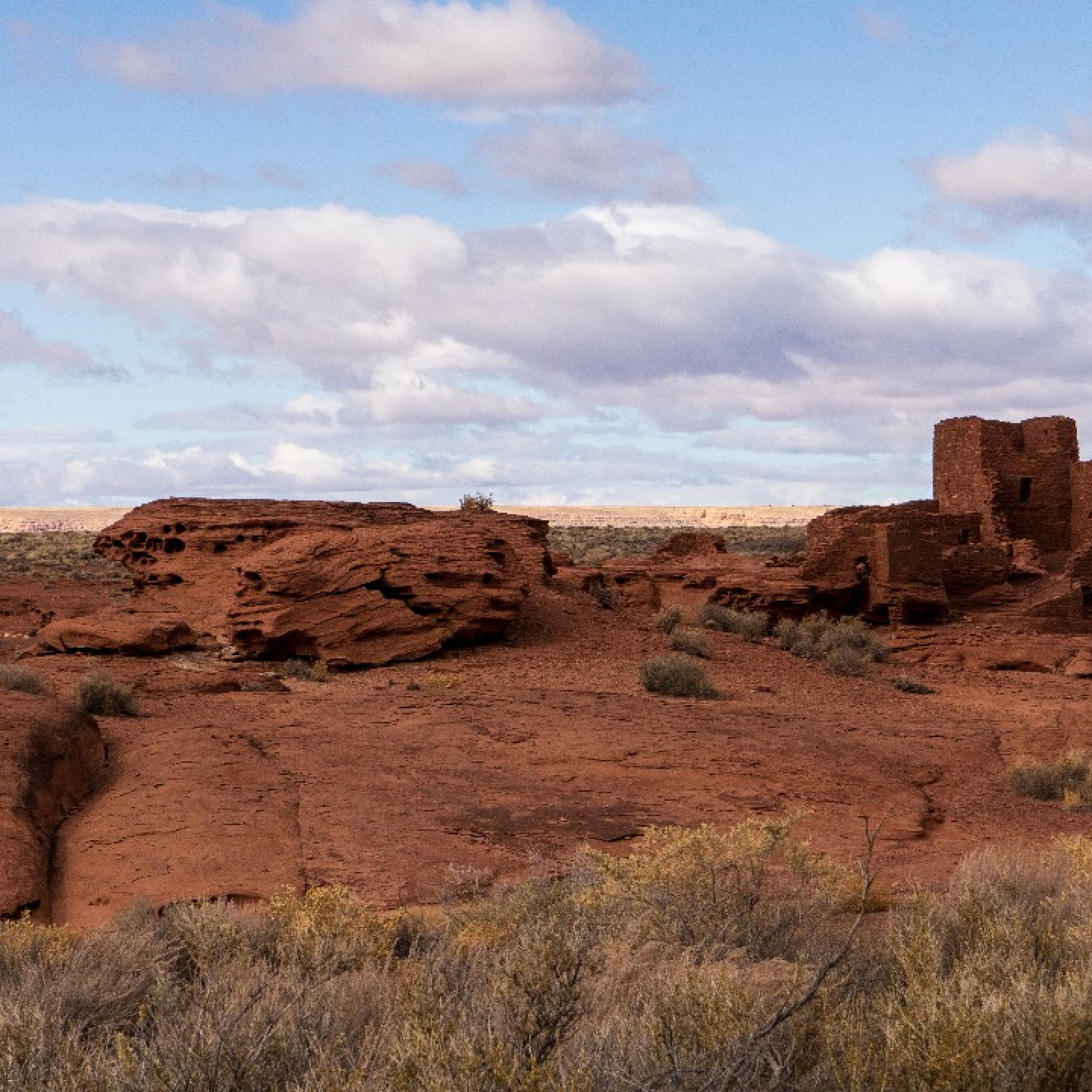 Wupatki Pueblo on a rock hill. Wupatki is in the desert of Arizona made with thin brown-reddish thin flat bricks.